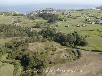 El castro de Mohías en primer término con el pueblo y puerto de Ortiguera al fondo